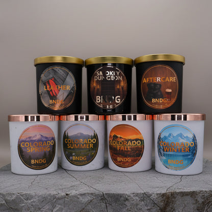 7 10oz jar candles with different scents on stone surface