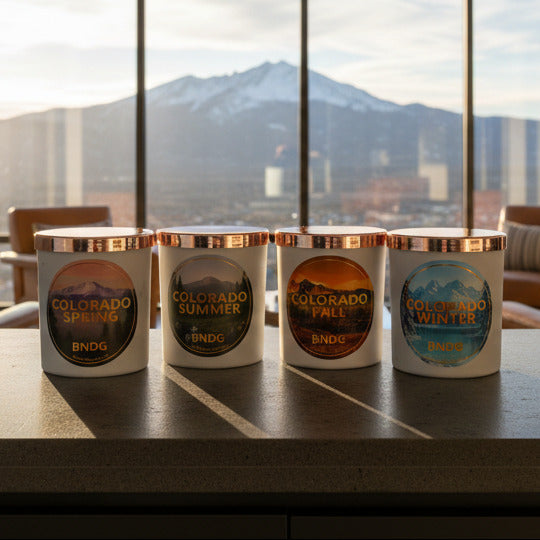 4 white candle jars in a living room with mountains in the distance