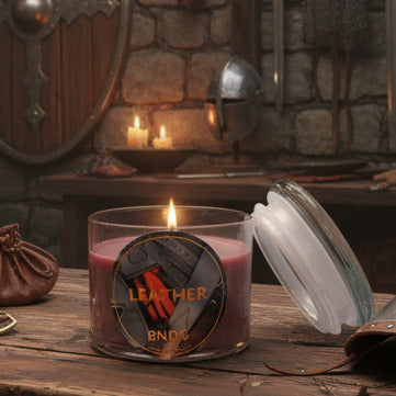 open, lit candle jar with "Leather"-scent on a table in a medieval armory