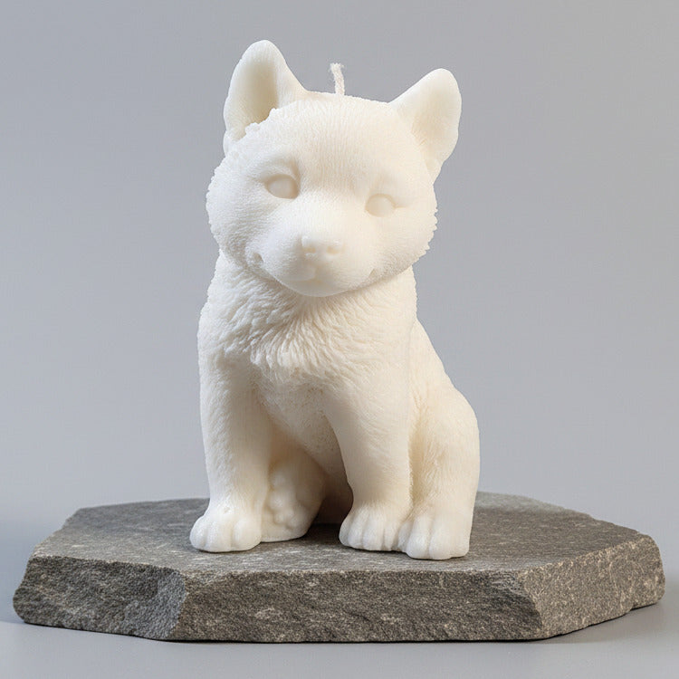 White dog figurine candle on a rock surface with a grey background