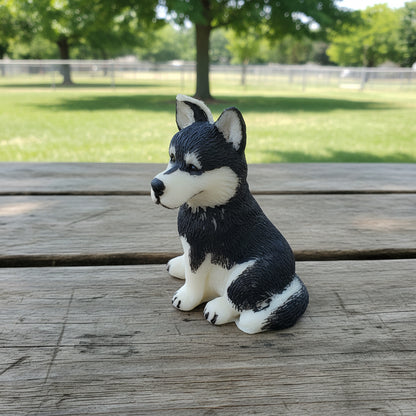 a small hand-painted husky candle on a wooden table in a park