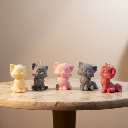 5 small, cute cat candles on a stone table with bright background