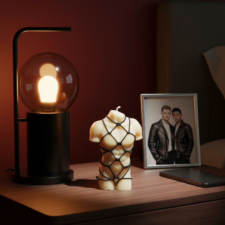 a white male torso candle with a black rope shibari torso on a nightstand