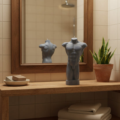 a grey male torso candle in a bathroom shelf in front of a mirror