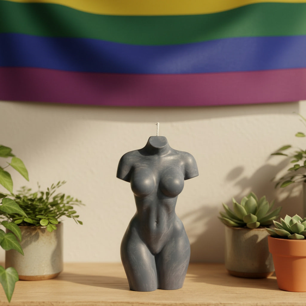 a grey female torso candle on a shelf with plants and a pride flag on the wall