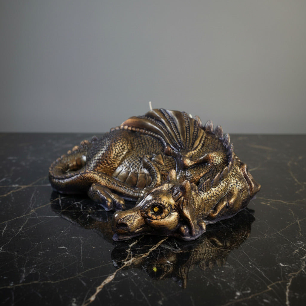 a gold hand-painted lazy dragn candle on black marble