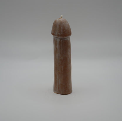 brown penis pillar candle on grey background