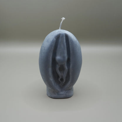 a dark grey vagina-shaped candle on grey background