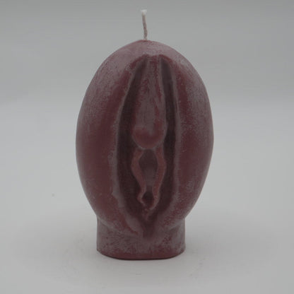 brown vagina-shaped candle on grey background