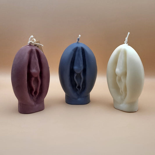 3 Vagina candles (Brown, black, white) with a beige background