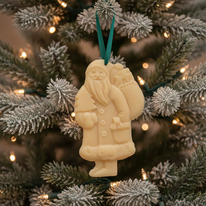 a santa beeswax ornament hanging on a christmas tree