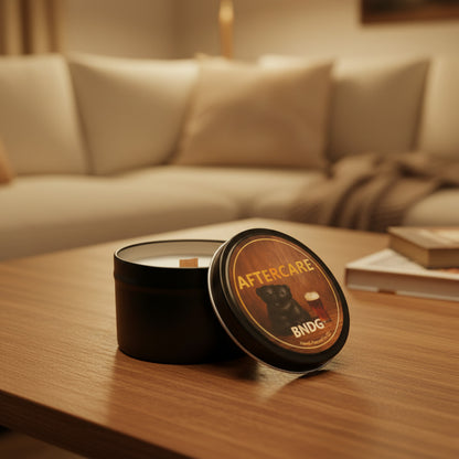 a candle tin with "Aftercare"-scent on a wooden table in front of a couch