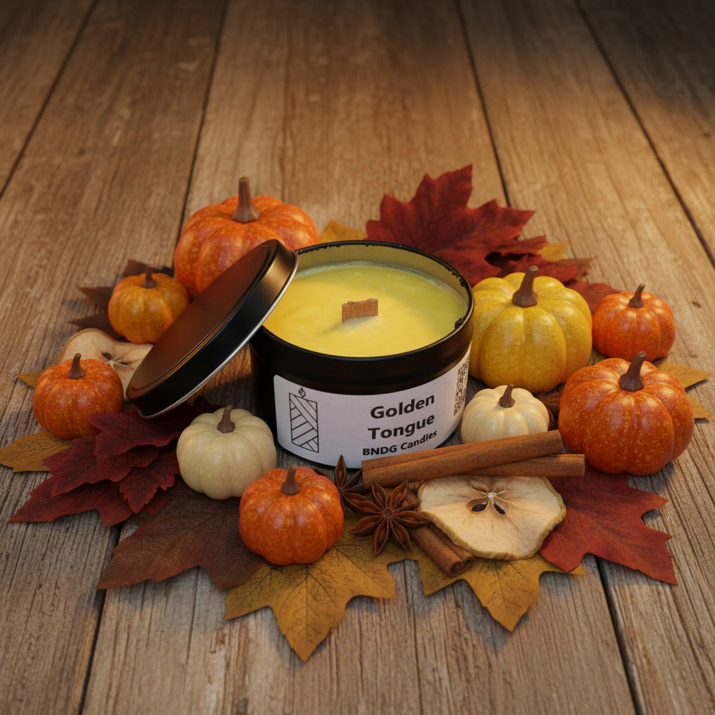 A candle time with "Golden tongue"-scent on a wooden table, surrounded by pumpkins, fall colored leaves and spices