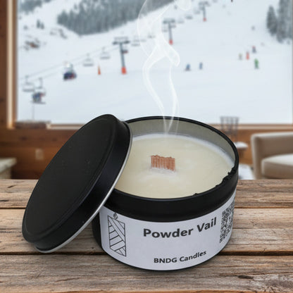 a candle tin with "Powder Vail"-scent in a cabin with the view of a ski resort 
