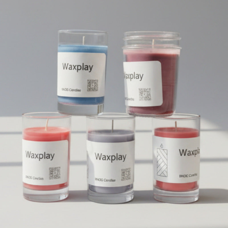 Five 'Waxplay' candles with labels on a surface.